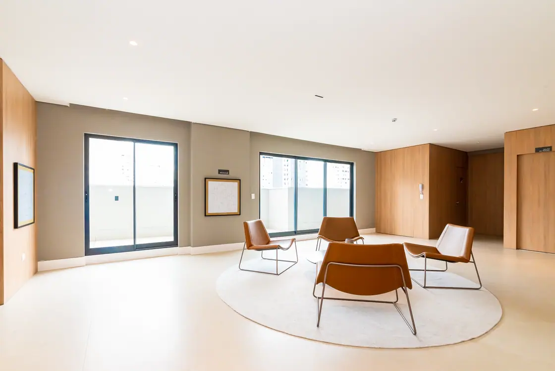 Sala de estar comum com poltronas, tapete redondo e luz natural